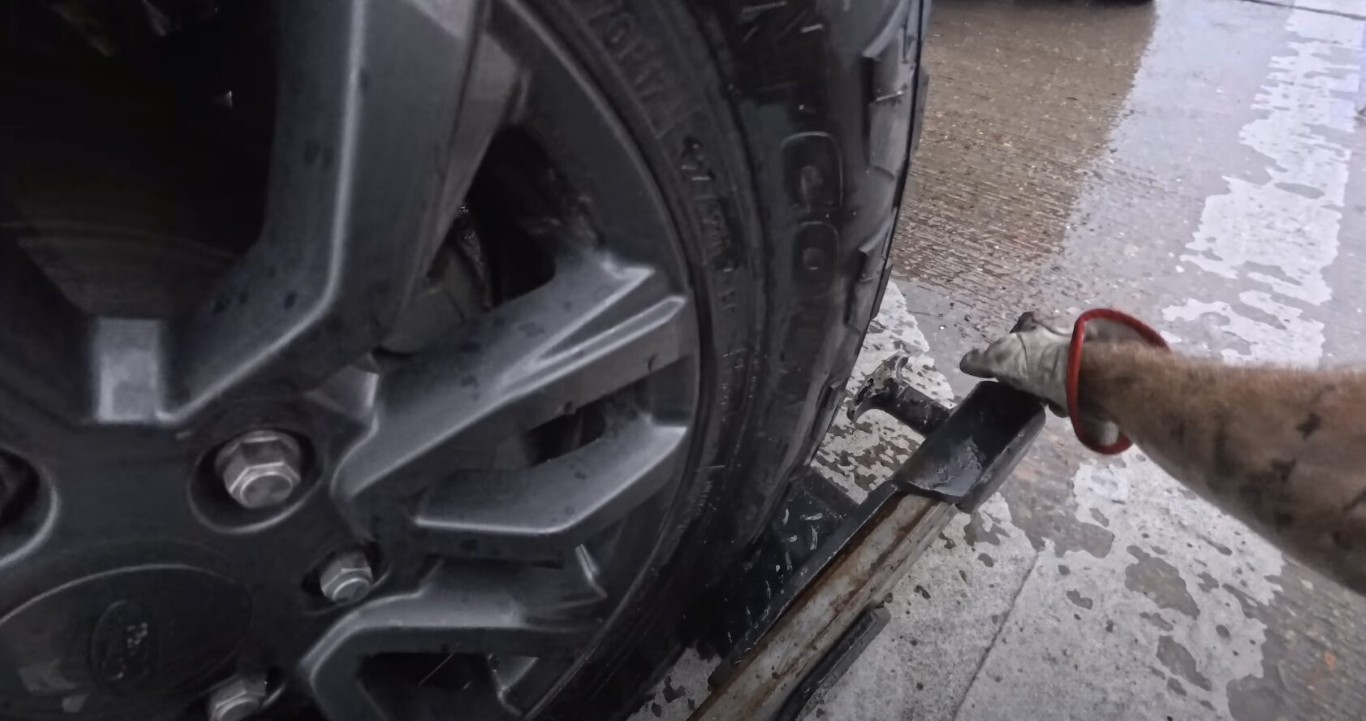 Professional roadside assistance technician changing flat tire in Papillion, Nebraska