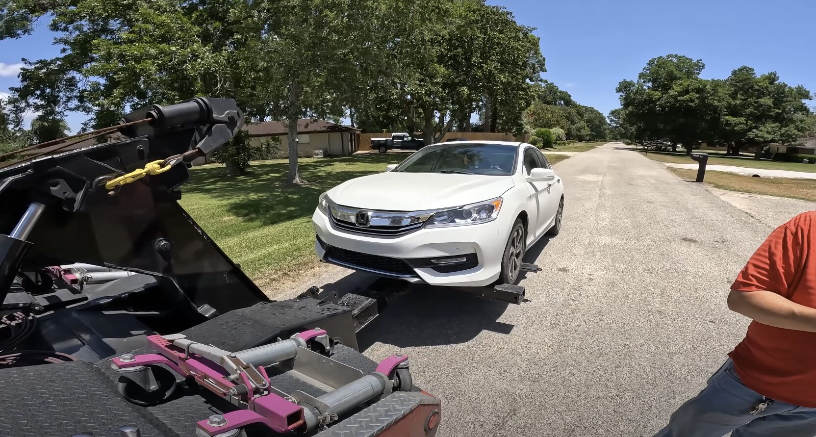 Emergency towing service loading white Honda Accord onto flatbed truck